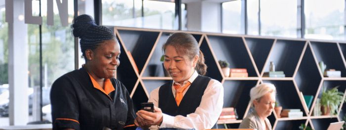 Schoonmaakmedewerkers kijken naar data op telefoon
